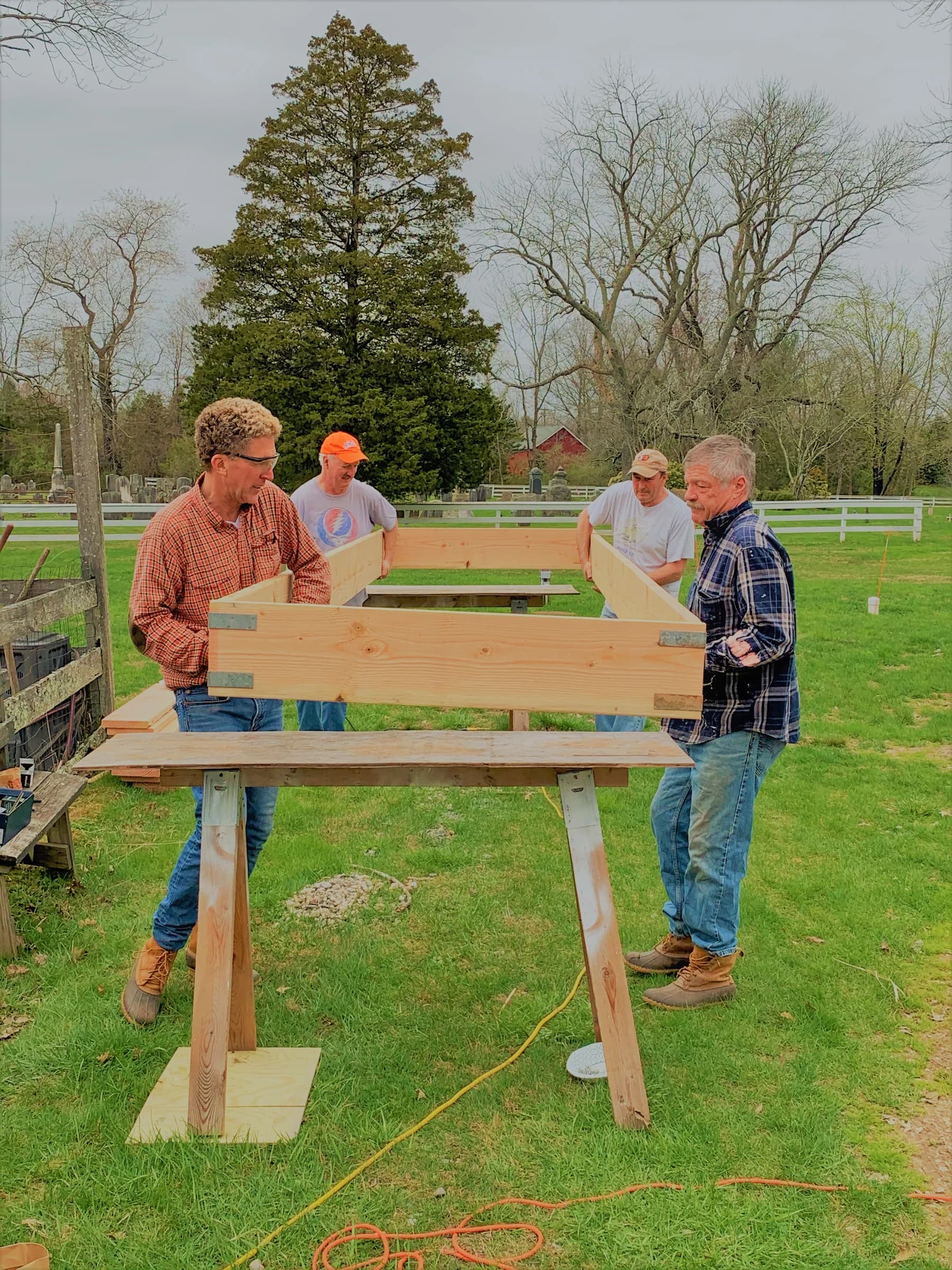 Volunteers building a raised garden bed together